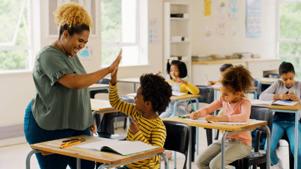 educación, choca los cinco y maestro con niños en el aula para el aprendizaje, el apoyo y la motivación. estudio, evaluación y desarrollo con el estudiante y la mujer en la escuela para la celebración, el examen y el resultado - teacher fotografías e imágenes de stock