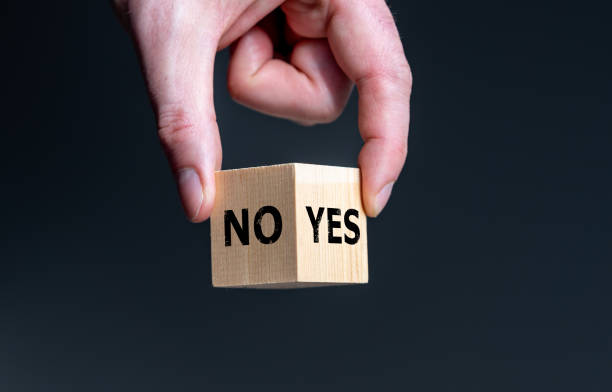 Symbol for the decision between yes and no. Wooden cube with the words 'yes' and 'no'. stock photo