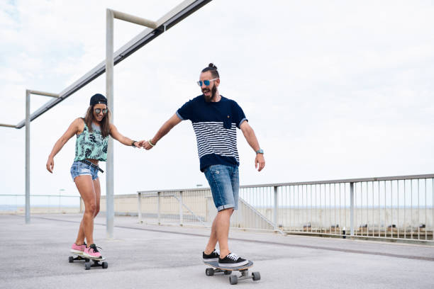 istock Couple skateboarding together. 1475877350