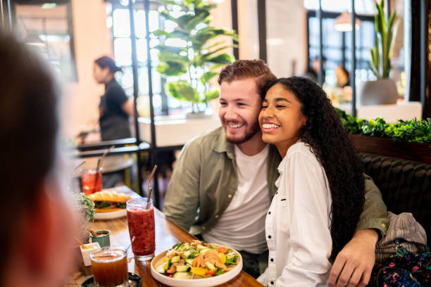 istock Couple embracing while talking with their friends on a restaurant 1475878994