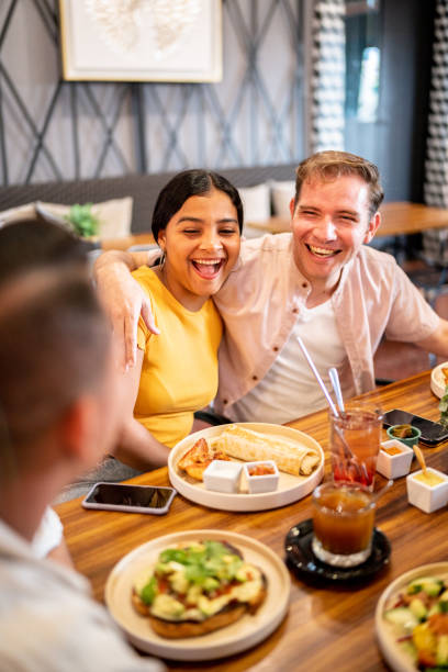 istock Couple embracing while talking with their friends on a restaurant 1475879065