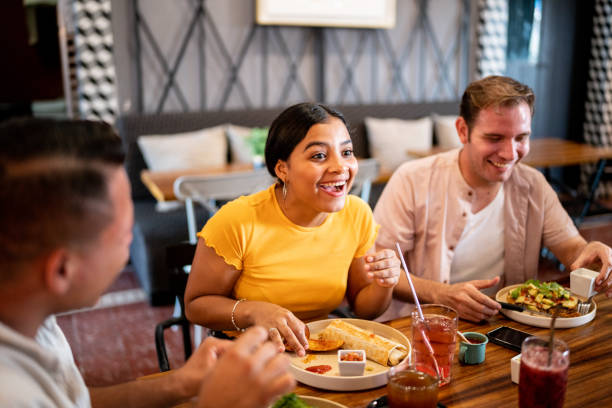 istock Young woman talking while eating with her friends on a restaurant 1475879212