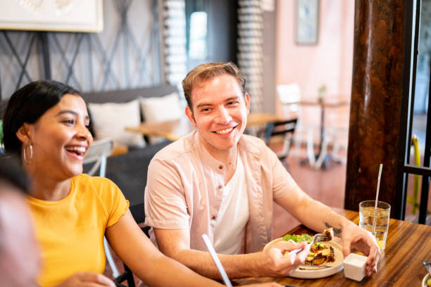 istock Young man talking while eating with his friends on a restaurant 1475879215