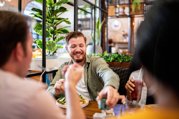 istock Young man eating with his friends on a restaurant 1475879309