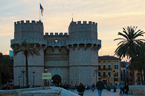 Valencia, Spain-December 28,2015:Sunset view of the Serranos Gate (Puerta de Serranos or Serranos Towers or Torres de Serranos). It was one of the 12 gates that formed part of the ancient city walls.