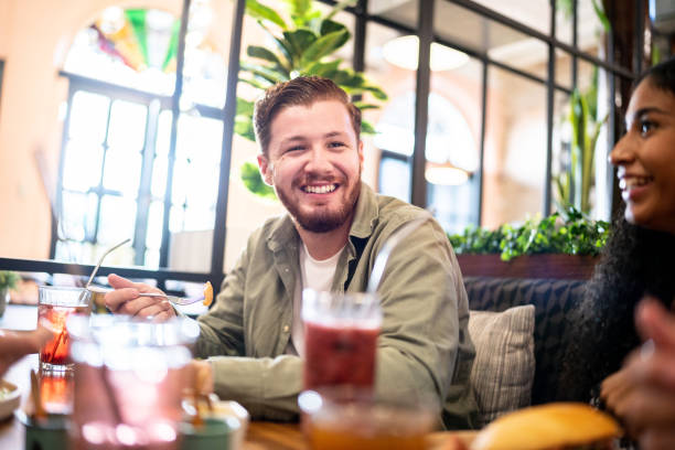 istock Young man talking while eating with his friends on a restaurant 1475879688
