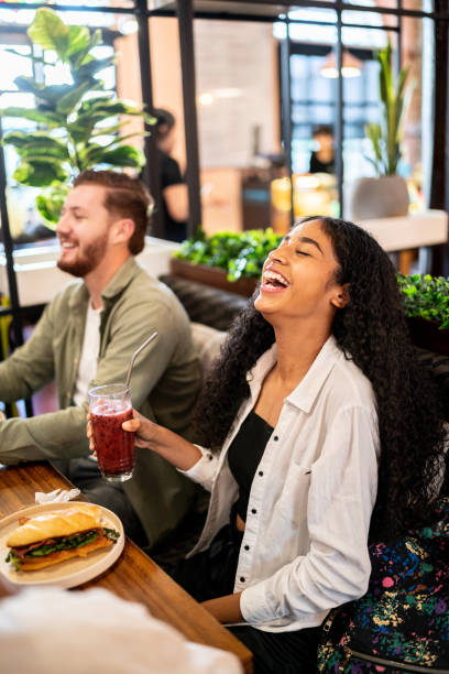 istock Young woman having fun while talking with her friends on a restaurant 1475879716