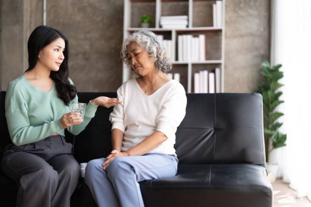 istock Unhappy Asian mother refuse taking medicines from her daughter hand 1475881022