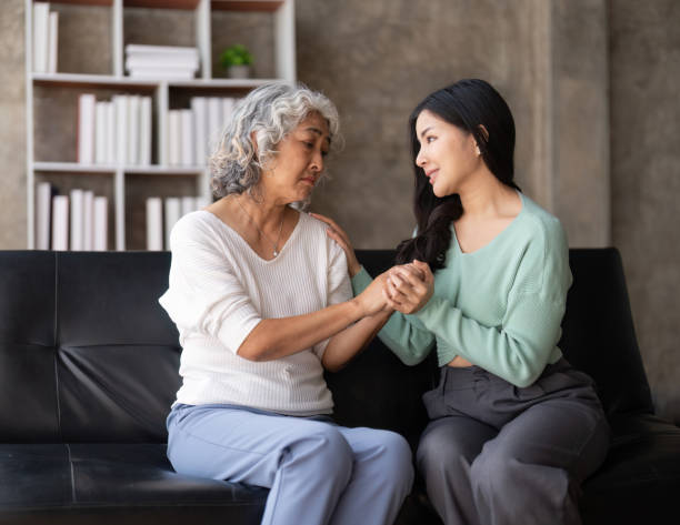 istock Daughter talking to sad mother holding hand comforting upset having problem 1475881084