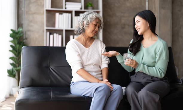 istock Unhappy Asian mother refuse taking medicines from her daughter hand 1475881170