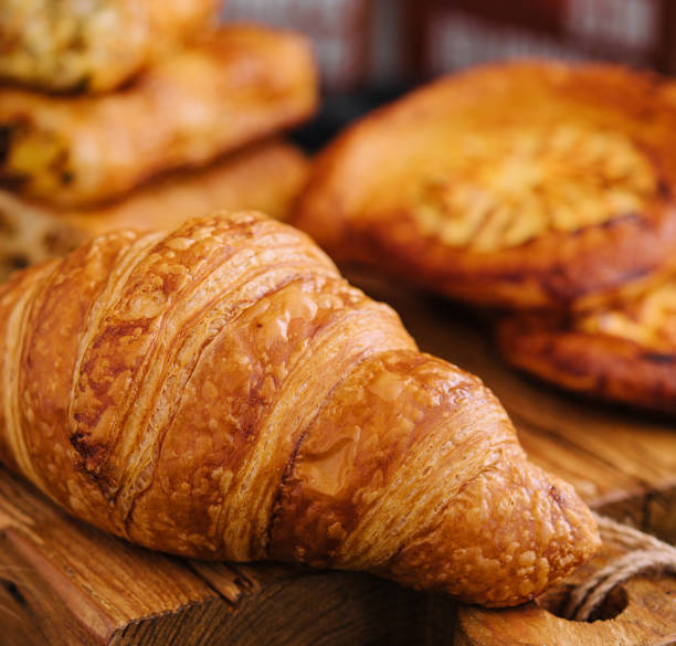istock Fresh croissant and buns on wooden board 1475881505