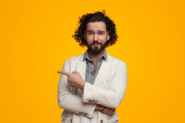 istock Stylish male pointing away in vibrant studio 1475881650