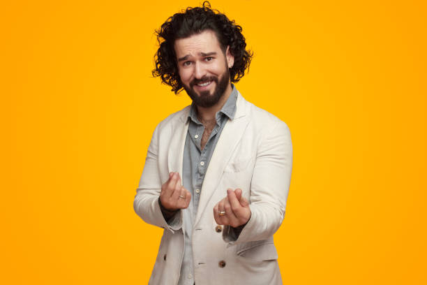 istock Smiling man making money gesture against yellow wall 1475881657