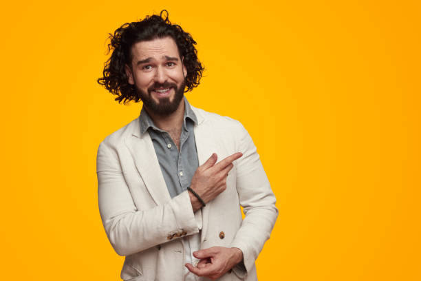 istock Cheerful man pointing away in bright studio 1475881670
