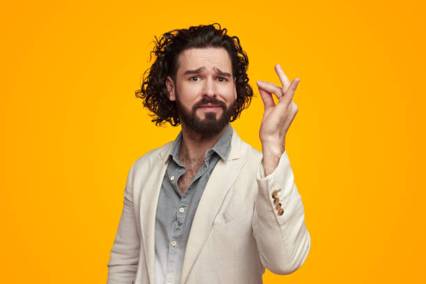 Bearded ethnic man showing excellent taste gesture in bright studio