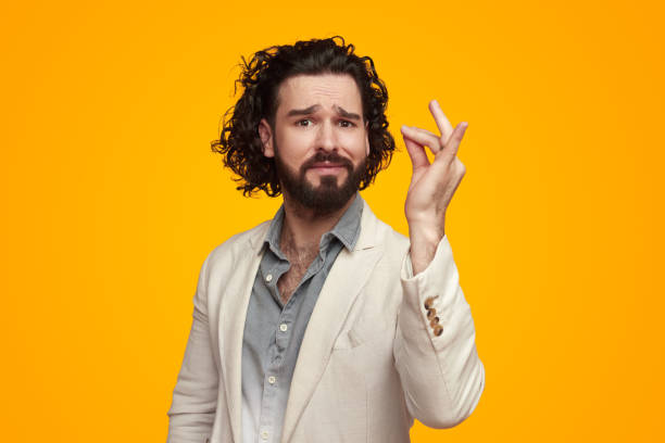 Bearded ethnic man showing excellent taste gesture in bright studio stock photo