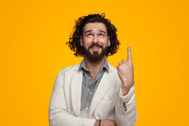istock Happy man pointing finger up in vivid studio 1475881683
