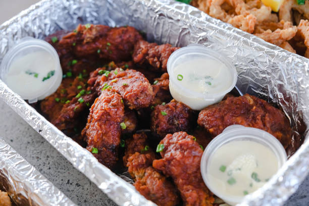 Close-up shot of crispy chicken buffalo wings with sour cream dipping sauce