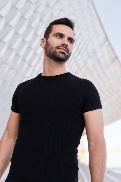 istock Content young bearded ethnic man looking away on street 1475885388
