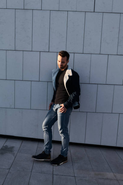 istock Stylish man leaning on tiled wall in city 1475885448
