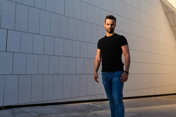 Portrait of Young Fashionable Adult Man in front of Metal Security Shutters in City
