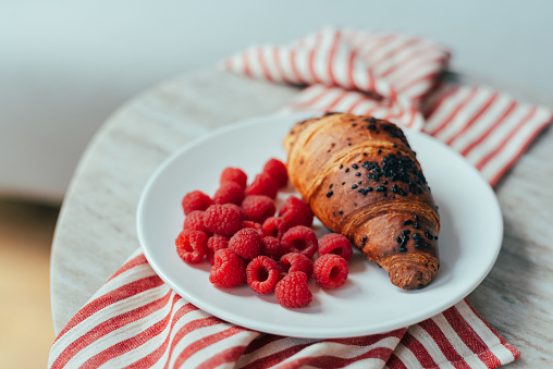 Chocolate croissant with raspberry for breakfast.