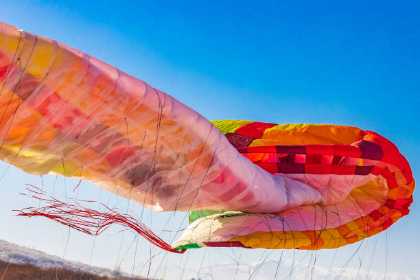 istock Close-up on the folding multi-colored wing of a paraglider during landing 1475890938