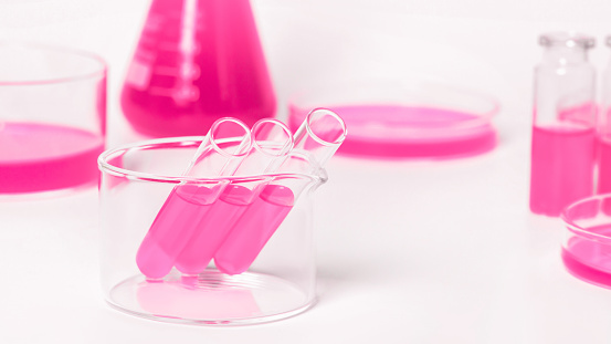 Test tubes for the laboratory with pink liquid.On the background of laboratory glassware. Petri dishes, flasks, test tubes. On a white, light background.