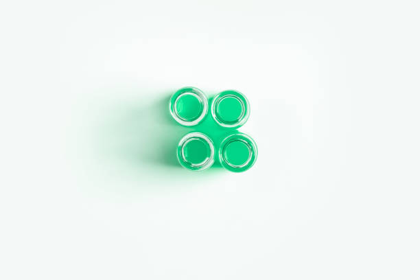 set of flasks, jars for laboratory with green liquid. On a white, light background. View from above.