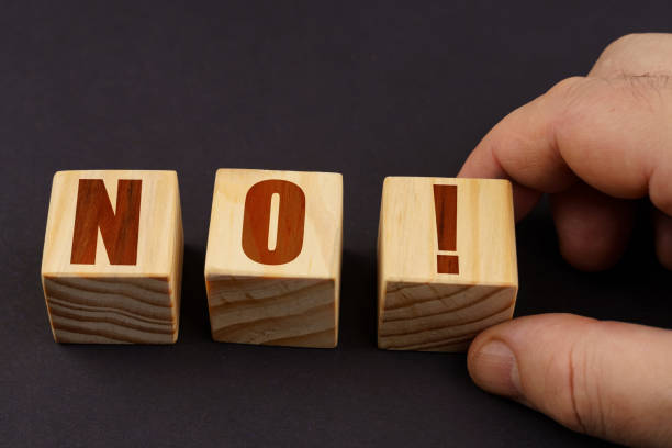 istock On a black surface, a man puts cubes with the inscription - NO 1475906293