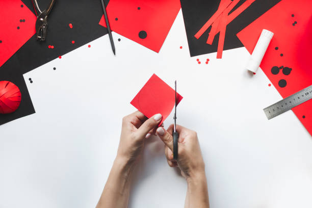 istock How to make paper red and black ladybug toy with children at home. Step by step instructions. Hands making DIY summer project. Top view. Step 2. Сut circle from red paper with diameter of 7.5 cm 1475911375