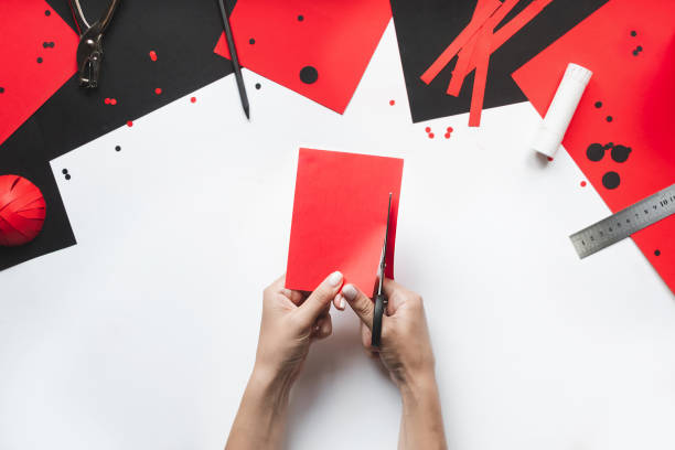 istock How to make paper red and black ladybug toy with children at home. Step by step instructions. Hands making DIY summer project. Top view. Step 4. ?utting paper into strips 1475911440