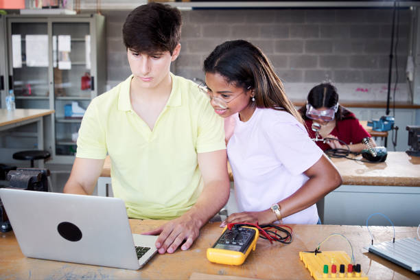 istock A boy and a girl students from the technical college using a laptop in technology class. Classmates collaborating on a project in high school - programming electric toys and robots at classroom 1475913885