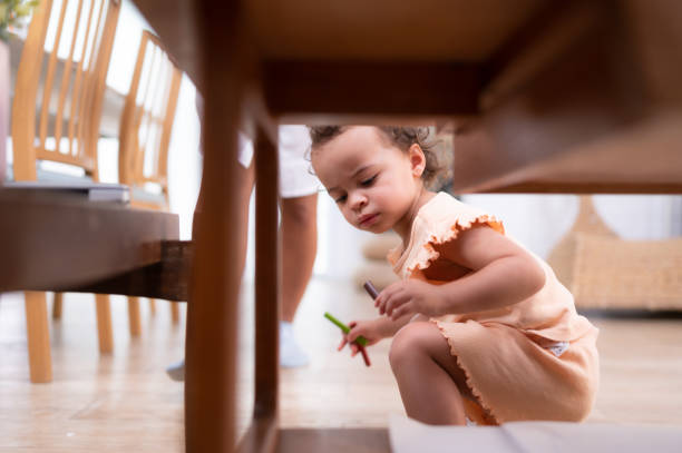 istock A little child's imagination is represented through colored pencil drawings, with the mother attentively supervising in the living room of the house. 1475917876