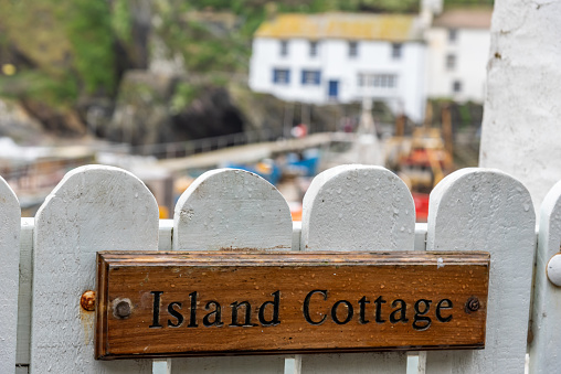 Island Cottage plate screwed on a white wooden fence in Cornwall Polpero UK