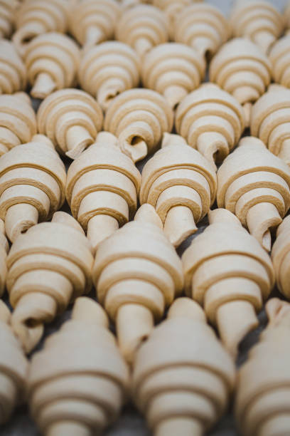 Unbaked croissants in a row on tray