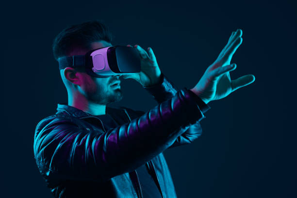 istock Man in VR glasses interacting with cyberspace in dark studio 1475933312