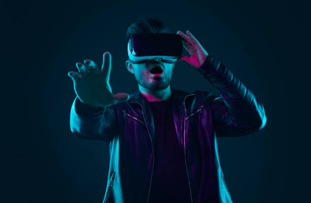 istock Shocked man in VR glasses in studio with neon lights 1475933339