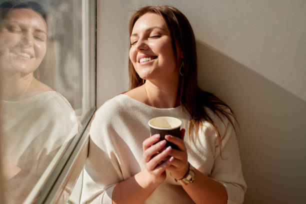 istock Happy woman with coffee in sunlight 1475933391