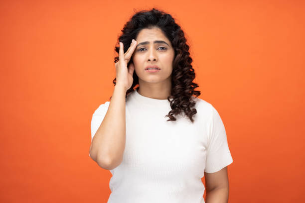 tired young woman with terrible headache touching head with hands stock photo stock photo
