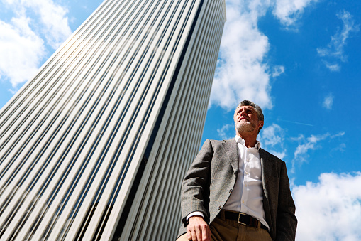 Low angle portrait of an elegant businessmen standing outside a skyscraper