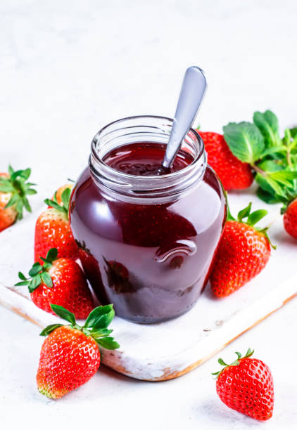 istock Strawberry jam in glass jar and fresh berries, white table background, copy space 1475952018