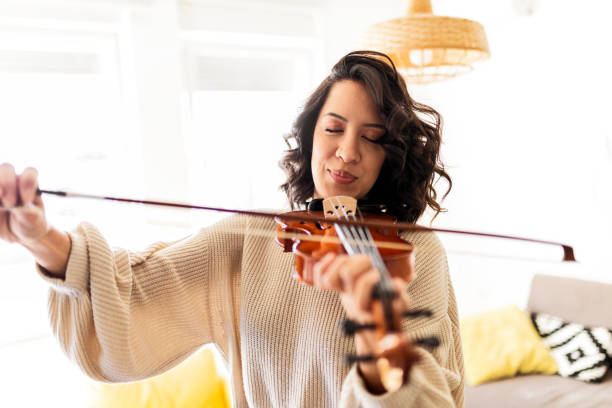 joven mujer tocando violín - violin women violinist music fotografías e imágenes de stock