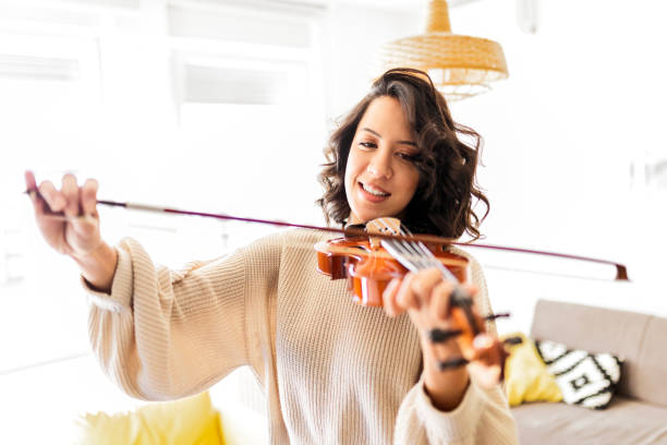istock Young woman violinist practicing at home 1475952202