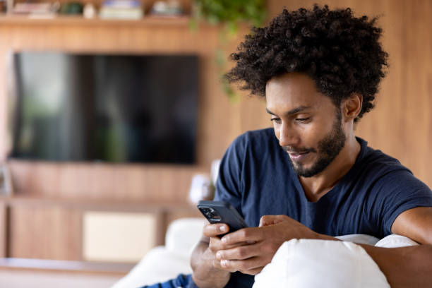 istock Man looking at social media on his cell phone while relaxing at home 1475954141