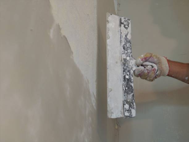 istock finishing plastering the wall with a wide spatula 1475956676