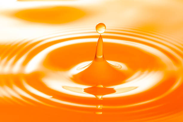 istock macro orange drop,Macro orange water drop texture,Falling drop in orange water with splash,The waves after a few drops of orange juice. 1475965502