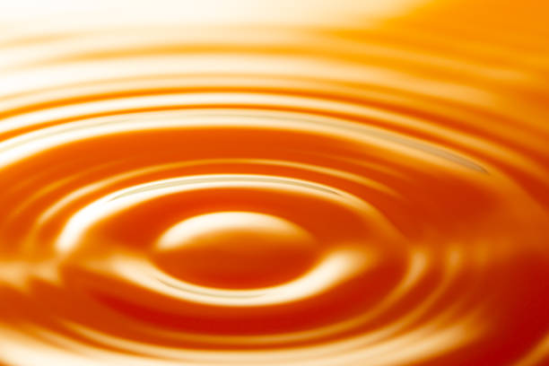 istock macro orange drop,Macro orange water drop texture,Falling drop in orange water with splash,The waves after a few drops of orange juice. 1475965503