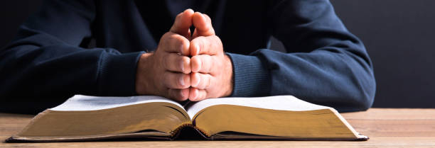 istock prayer man hand on Bible 1475968205