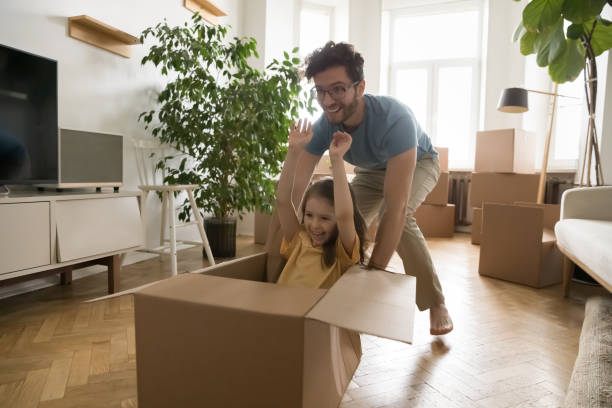 istock Cheerful excited dad pushing forward cardboard box with little daughter 1475969946